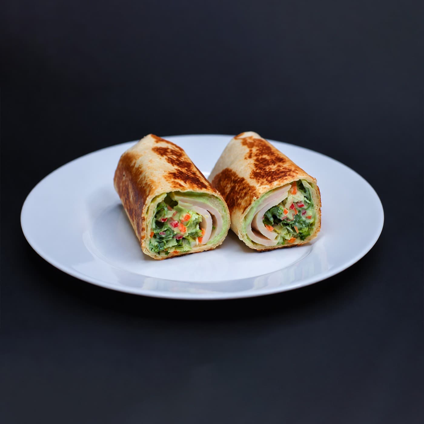 Zapečene tortilje presečene na pola, punjene avokadom, zelenišem, paprikom i mesom.